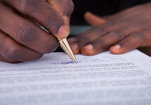 man signing a document
