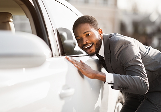 man staring at the side of his car