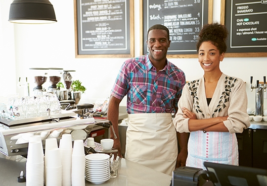 two barristas behind a coffee counter