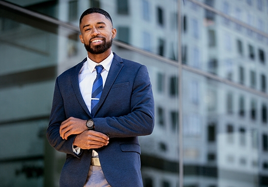man in business suit standing in front of office building