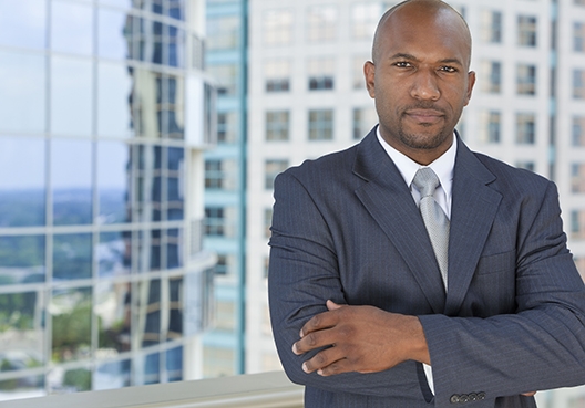 man in business suit standing by an office window