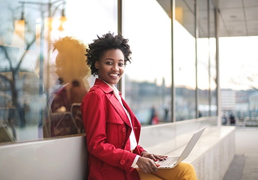 Young lady sitting outside with her laptop on her lap