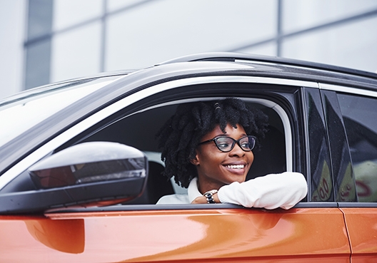 man sitting in the driver's seat with his window rolled down, looking out the open window
