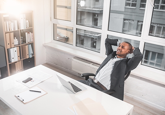 man sitting by his desk leaning back